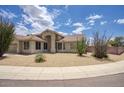 Single-story home with neutral stucco, tiled roof, and desert landscaping with mature plants at 4141 W Potter Dr, Glendale, AZ 85308
