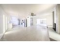 Spacious living room with a ceiling fan, fireplace and modern tile flooring at 4528 W Butler Dr, Glendale, AZ 85302