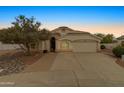 Dusk view of a charming single-story home with a well-maintained lawn, desert landscaping, and inviting curb appeal at 662 S Saddle St, Gilbert, AZ 85233