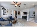 Bright, open-concept living room with modern furnishings, a ceiling fan, and a staircase at 6907 S 8Th Dr, Phoenix, AZ 85041