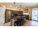 Well-equipped kitchen with stainless steel appliances, a large island, and dark wood cabinets at 6932 W Harwell Rd, Laveen, AZ 85339