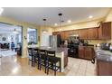 Well-appointed kitchen with stainless steel appliances, an island with barstool seating, and ample storage at 6932 W Harwell Rd, Laveen, AZ 85339