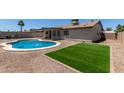 Spacious backyard featuring a sparkling blue pool, a manicured lawn, and desert landscaping at 701 W Mesquite St, Chandler, AZ 85225