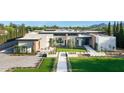 Expansive aerial view of a modern home with manicured lawns, desert landscaping, and a geometric design at 7341 E Sunnyside Dr, Scottsdale, AZ 85260