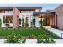 Stunning modern home with desert landscaping, manicured lawn, and large windows, creating an inviting curb appeal at 7341 E Sunnyside Dr, Scottsdale, AZ 85260