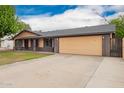 Single-story house featuring a spacious driveway and large garage at 7755 W Cora Ln, Phoenix, AZ 85033