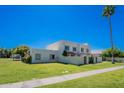Well-maintained home featuring a lush lawn, mature palm trees, and a charming exterior facade at 7830 E Valley Vista Dr, Scottsdale, AZ 85250