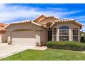 Charming single-story home with a tile roof, manicured lawn, and a two-car garage on a sunny day at 7930 W Wescott Dr, Glendale, AZ 85308