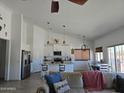 Bright, open-concept living space with vaulted ceilings, modern kitchen, and dining area at 8678 S John Jacob Astor Ave, Casa Grande, AZ 85193