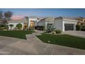 Stunning single-story home with lush green lawn and manicured landscaping at dusk at 9265 N 115Th St, Scottsdale, AZ 85259