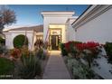 Charming home featuring a manicured walkway leading to the front entrance at dusk at 9265 N 115Th St, Scottsdale, AZ 85259