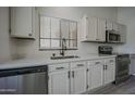 Bright kitchen featuring white cabinets, stainless steel appliances, and a view to the outside at 9813 W Mcrae Way, Peoria, AZ 85382