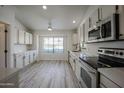 Modern kitchen with stainless steel appliances, white cabinets, and an open layout at 9813 W Mcrae Way, Peoria, AZ 85382