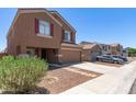 Charming two-story home features a two-car garage and well-maintained front yard with stone pathway at 10745 W Taft St, Phoenix, AZ 85037