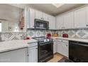 Well-lit kitchen featuring stainless steel appliances, stylish backsplash, and white cabinets at 11680 E Sahuaro Dr # 1059, Scottsdale, AZ 85259