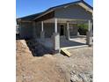 Exterior view of a single-story gray home with a concrete patio and a carport with support beams at 1210 E Garfield St, Phoenix, AZ 85006