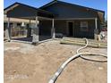 View of a single-story gray home with a partially finished concrete patio and a carport in progress at 1210 E Garfield St, Phoenix, AZ 85006