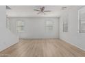Bright living room with neutral paint, wood floors, a ceiling fan, and sun-filled windows at 1265 S Aaron -- # 271, Mesa, AZ 85209