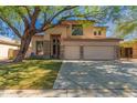 Inviting two-story home with a well-manicured lawn, mature trees, and a three-car garage at 1453 E Elgin Pl, Chandler, AZ 85225