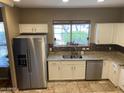 Kitchen featuring stainless steel refrigerator, granite countertops, and views from the window at 14575 W Mountain View Blvd # 711, Surprise, AZ 85374