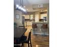 Open-concept kitchen and dining area with granite countertop bar and pendant lighting at 14575 W Mountain View Blvd # 711, Surprise, AZ 85374