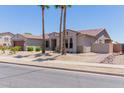 Inviting single-story home with desert landscaping and tall palm trees in the front yard at 15753 W Christy Dr, Surprise, AZ 85379