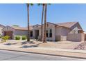 Attractive single-story home with palm trees providing shade in the xeriscaped front yard at 15753 W Christy Dr, Surprise, AZ 85379