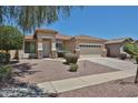 A single-story home with a landscaped front yard and a two-car garage beneath a clear blue sky at 16874 W Tonbridge St, Surprise, AZ 85374