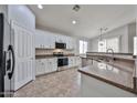 Bright kitchen featuring white cabinetry, stainless steel appliances, tile flooring, and granite countertops at 16874 W Tonbridge St, Surprise, AZ 85374