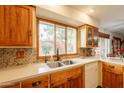 Well-lit kitchen featuring wood cabinets, quartz countertops, and a window view of the charming landscaped outdoors at 1708 E Westchester Dr, Tempe, AZ 85283