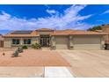 Charming home featuring a three car garage and a well-manicured front yard with desert landscaping and solar panels at 1744 E Fremont Rd, Phoenix, AZ 85042