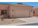 Tan home featuring a two car garage, desert landscaping and a tile roof at 18650 N 91St Ave # 3301, Peoria, AZ 85382