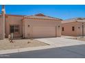Tan home featuring a two car garage, desert landscaping and a tile roof at 18650 N 91St Ave # 3301, Peoria, AZ 85382