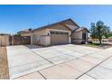 Wide shot of the house showing a driveway with gated access and the two-car garage at 18675 W Foothill Dr, Surprise, AZ 85387