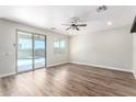 Spacious living room with wood-look floors, a ceiling fan, and sliding doors leading to the backyard pool at 18675 W Foothill Dr, Surprise, AZ 85387