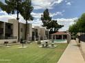 Beautiful community with pool, covered seating, mature shade trees, and barbeque grills at 1927 E Hampton Ave # 260, Mesa, AZ 85204