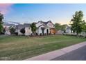 Well-manicured front lawn with mature trees, complementing the home's sophisticated exterior design at 20649 E Vallejo Ct, Queen Creek, AZ 85142