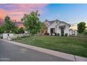 Charming white brick home with lush green lawn and elegant white rose bushes along the pathway at 20649 E Vallejo Ct, Queen Creek, AZ 85142