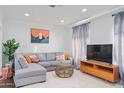 Comfortable living room with gray sectional sofa, decorative pillows, and media cabinet at 2227 N 16Th Ave, Phoenix, AZ 85007