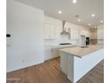 Bright, spacious kitchen featuring an expansive island, white cabinets, and modern stainless steel appliances at 22699 E Happy Rd, Queen Creek, AZ 85142