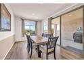 Bright dining room with wood floors, a large window, and a sliding glass door leading to the patio at 27606 W Tonopah Dr, Buckeye, AZ 85396