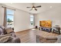 Comfortable living room with hardwood flooring, a ceiling fan, two large windows, and plush seating at 27606 W Tonopah Dr, Buckeye, AZ 85396