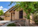 This home has a tan exterior, a two-car garage, desert landscaping, and stone accents at 29751 N 119Th Ln, Peoria, AZ 85383