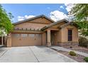 Inviting single-story home with a tan exterior, a two-car garage, and a decorative stone facade at 29751 N 119Th Ln, Peoria, AZ 85383