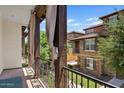 Outdoor balcony with wrought iron railing, wood columns, and outdoor drapes, offering scenic neighborhood views at 3623 E Horace Dr, Gilbert, AZ 85296