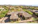 Aerial view of a desert home showing a stone and stucco exterior with tile roof and desert landscaping at 37301 N 99Th St, Scottsdale, AZ 85262