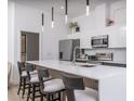 Stylish kitchen featuring a quartz countertop island with bar seating, stainless steel appliances, and modern pendant lighting at 4220 N 32Nd St # 31, Phoenix, AZ 85018