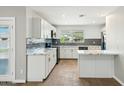 White kitchen featuring modern appliances, backsplash, marble countertops, and ample cabinet space at 428 E Kachina Trl, Phoenix, AZ 85042