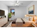 Cozy bedroom filled with natural light, featuring soft decor, and a ceiling fan at 43530 W Eddie Way, Maricopa, AZ 85138