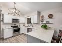 Bright kitchen featuring modern white cabinets, stainless steel appliances, and quartz countertops at 5808 E Lawndale St, Mesa, AZ 85215